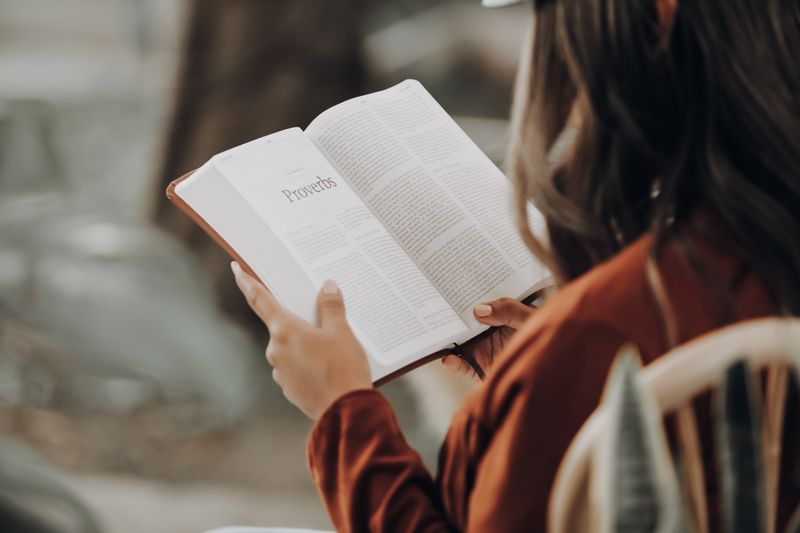 Žena čita Mudre izreke u Bibliji